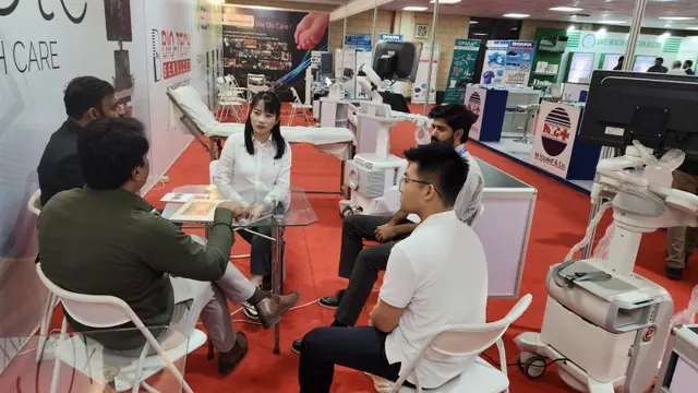 Visitors in discussion at the Esaote stand